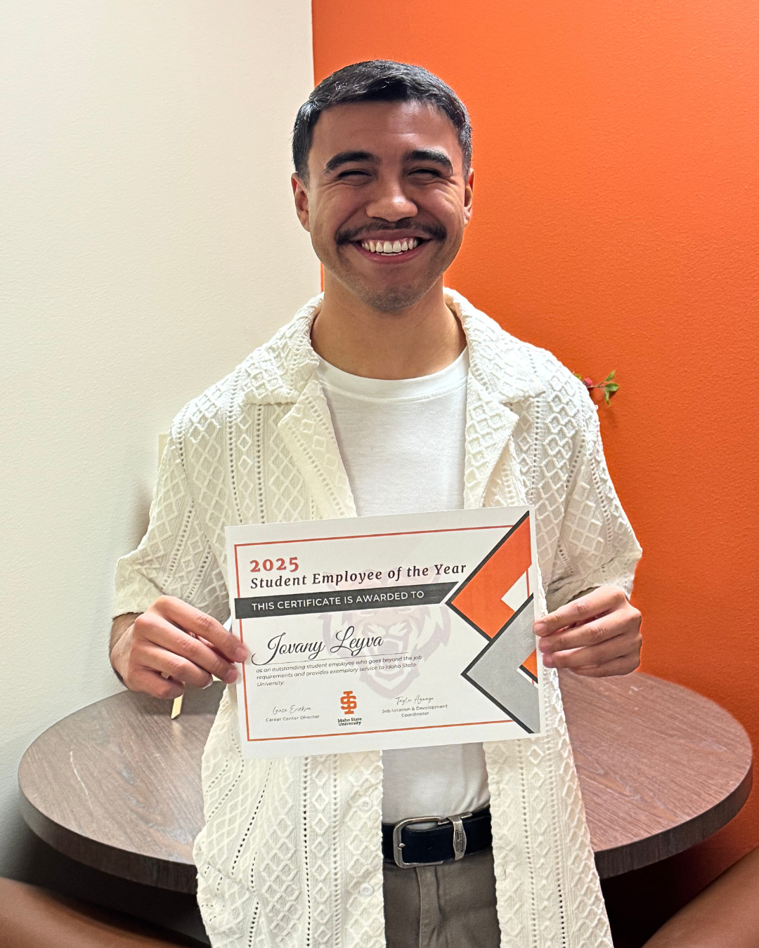 Jovany smiling as he hold the Student Employee of the Year Award.