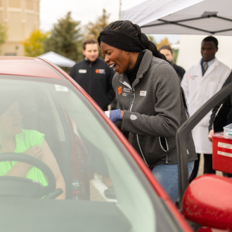 student giving person in car immunization