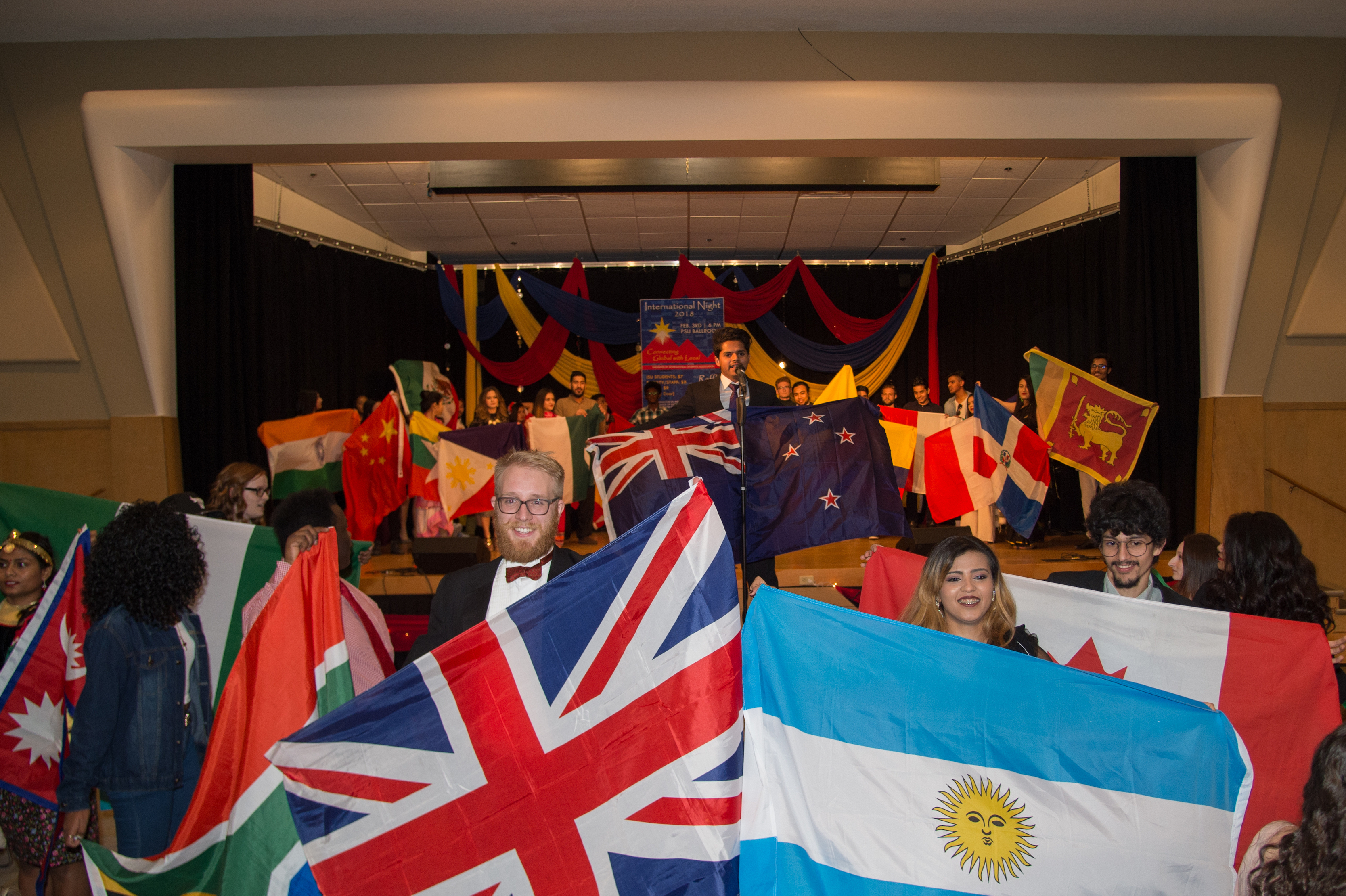 A room full of students holding up different countries flags