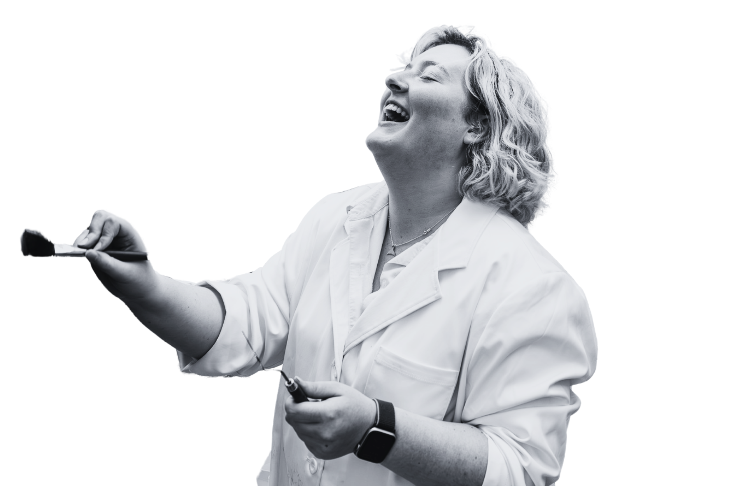 Emily paints on a canvas with head thrown back in laughter