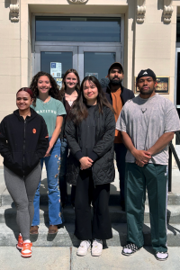 Group photo of the 6 class members standing outside a building