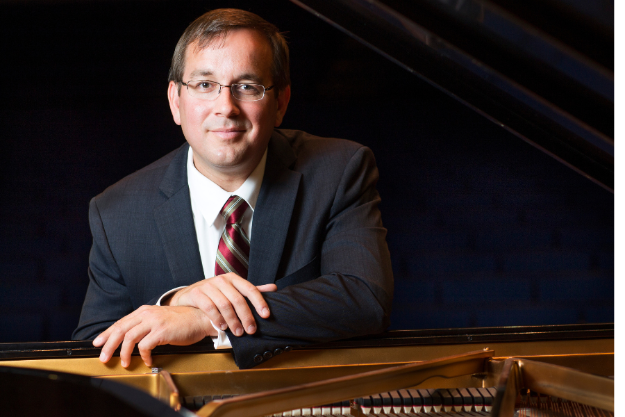 Francom sits at a grand piano