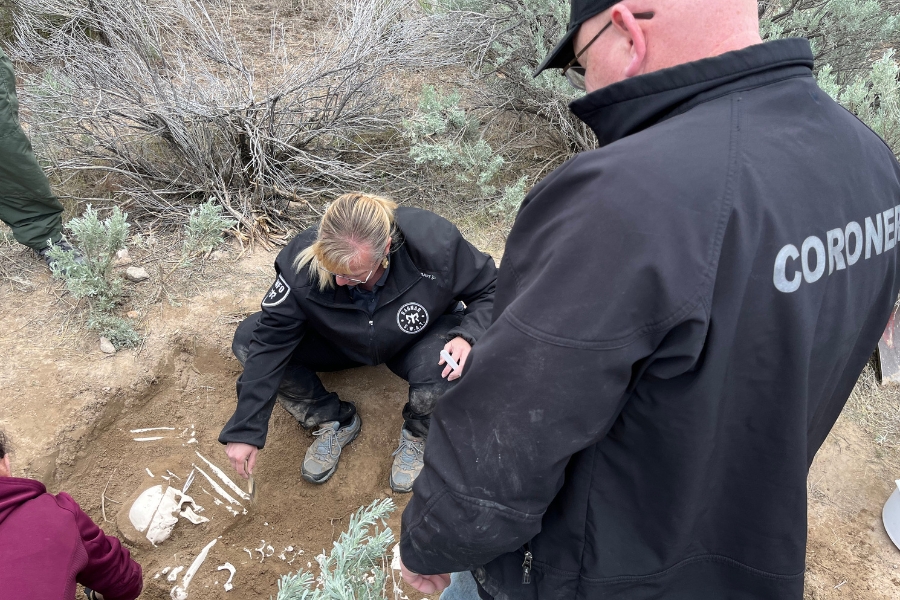 A group gathered around a skeleton in the ground