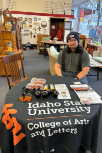 Dean Clinton sits at a table in an antique shop