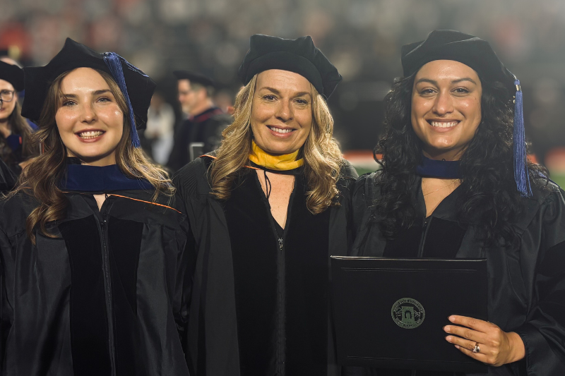 3 students in graduate regalia