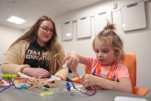Idaho State University elementary education graduate works with a elementary student teaching them science, technology, engineering, and mathematics skills and knowledge in a classroom.