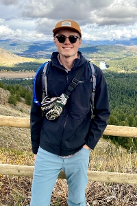 Ethan Harrow portrait in from of a green valley