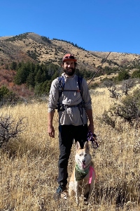 Jennings Leavell poses in an arid wilderness with his cute dog