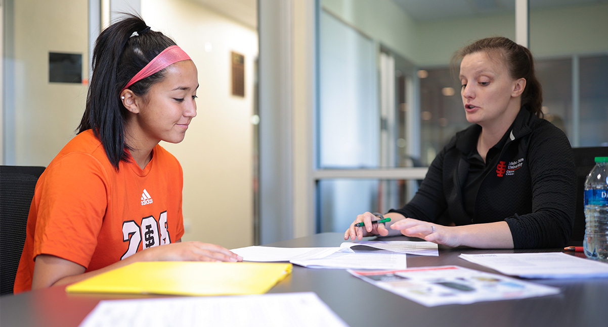 Student and instructor working at a table