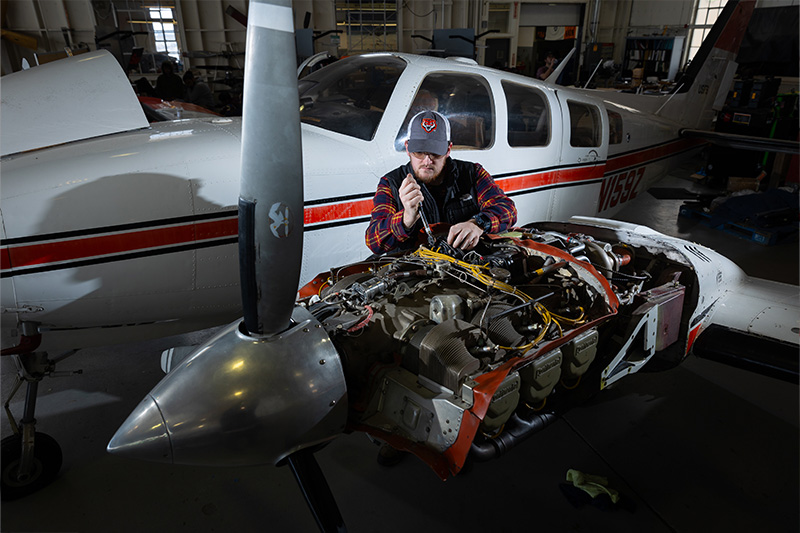 Aircraft Maintenance student working on an airplane engine