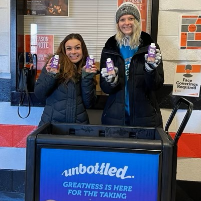 Two students at a dairy west fundraiser handing out milk