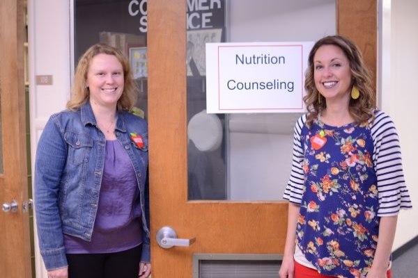 two female dietitians in front of a nutrition counseling sign