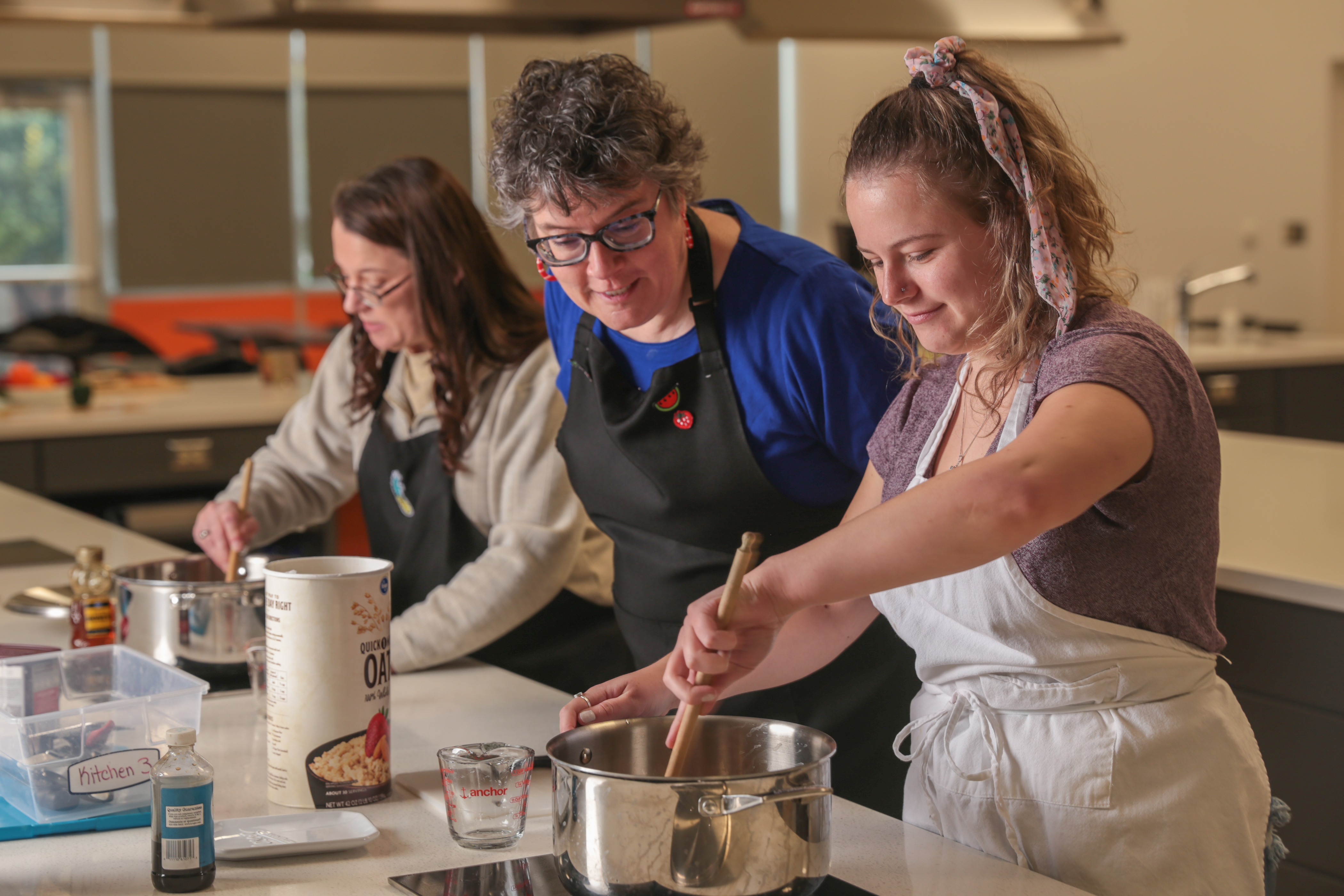 Professor assisting students in a foods lab