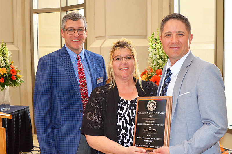 Dr. Rex Force and Wendy Mickelsen award Casey Dye the KDHS 2018 Professional Achievement Award