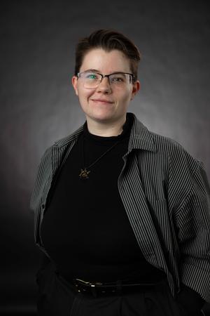 Azraiel Raines, Global Studies alum, smiling in a studio portrait.