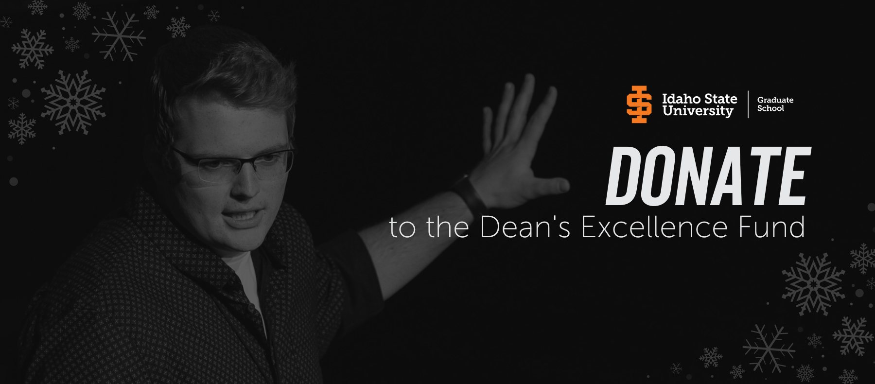 A black and white photo of a student gesturing to a presentation behind him.