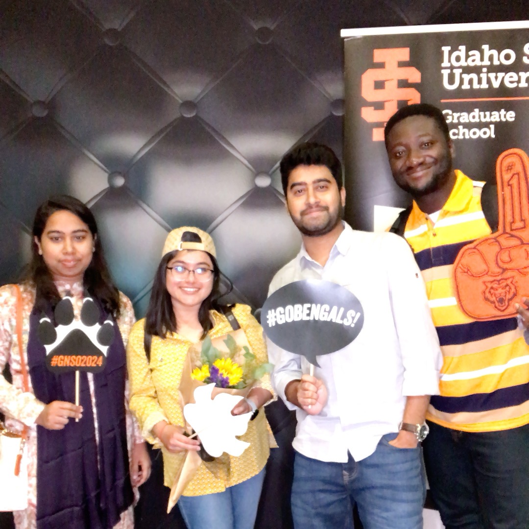 4 students at orientation posing with photobooth props for a photobooth picture