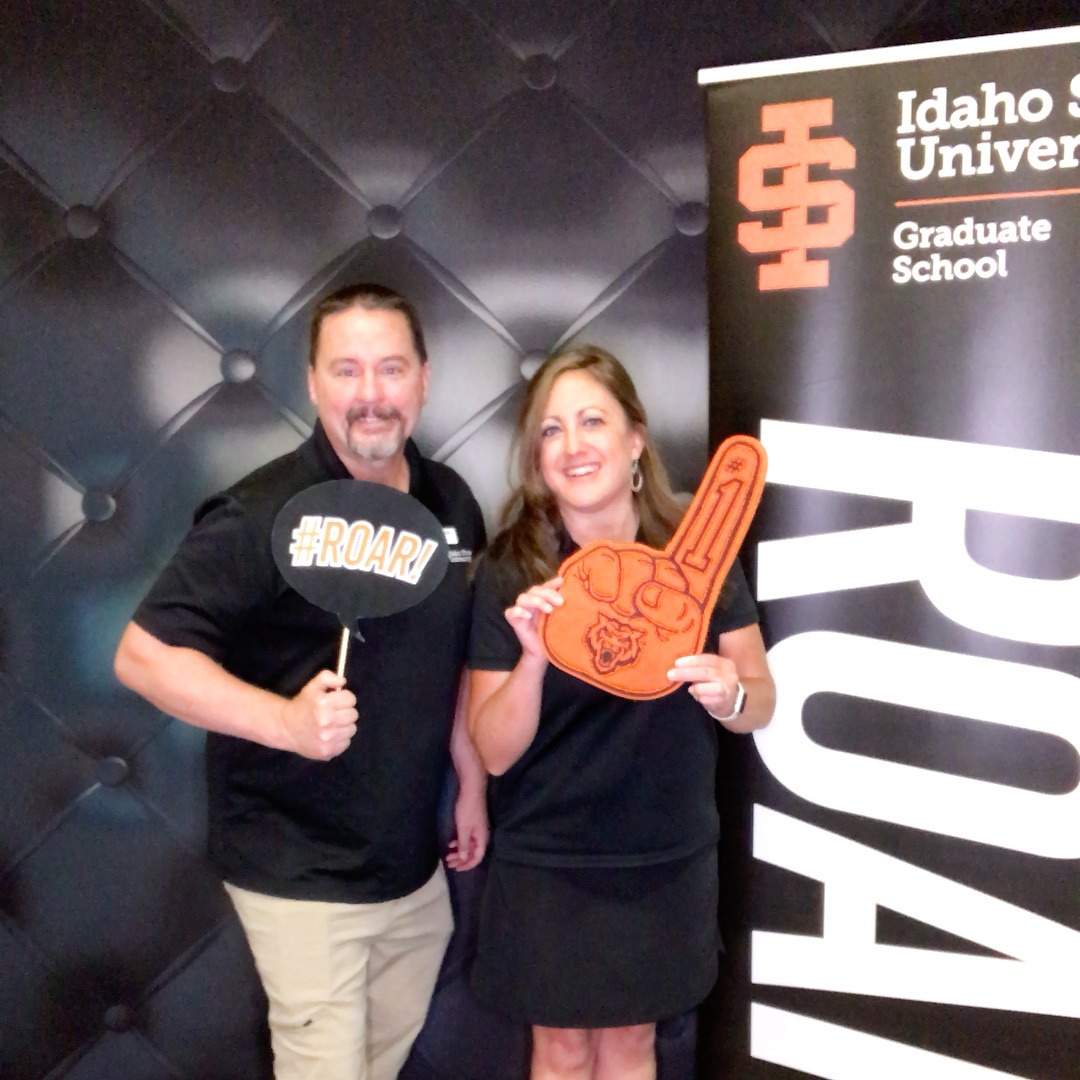 2 faculty members at orientation posing with photobooth props for a photobooth picture