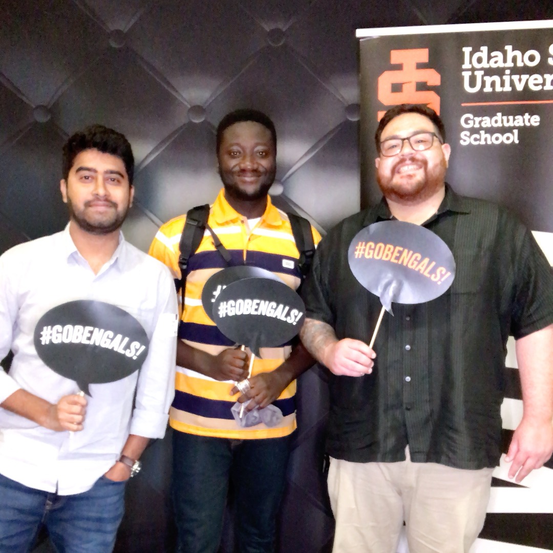 3 students at orientation posing with photobooth props for a photobooth picture