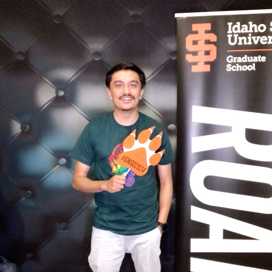 A student at orientation posing with a photobooth prop for a photobooth picture