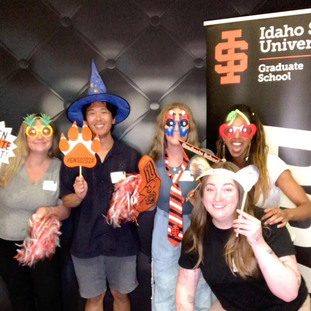 5 students at orientation posing with photobooth props for a photobooth picture