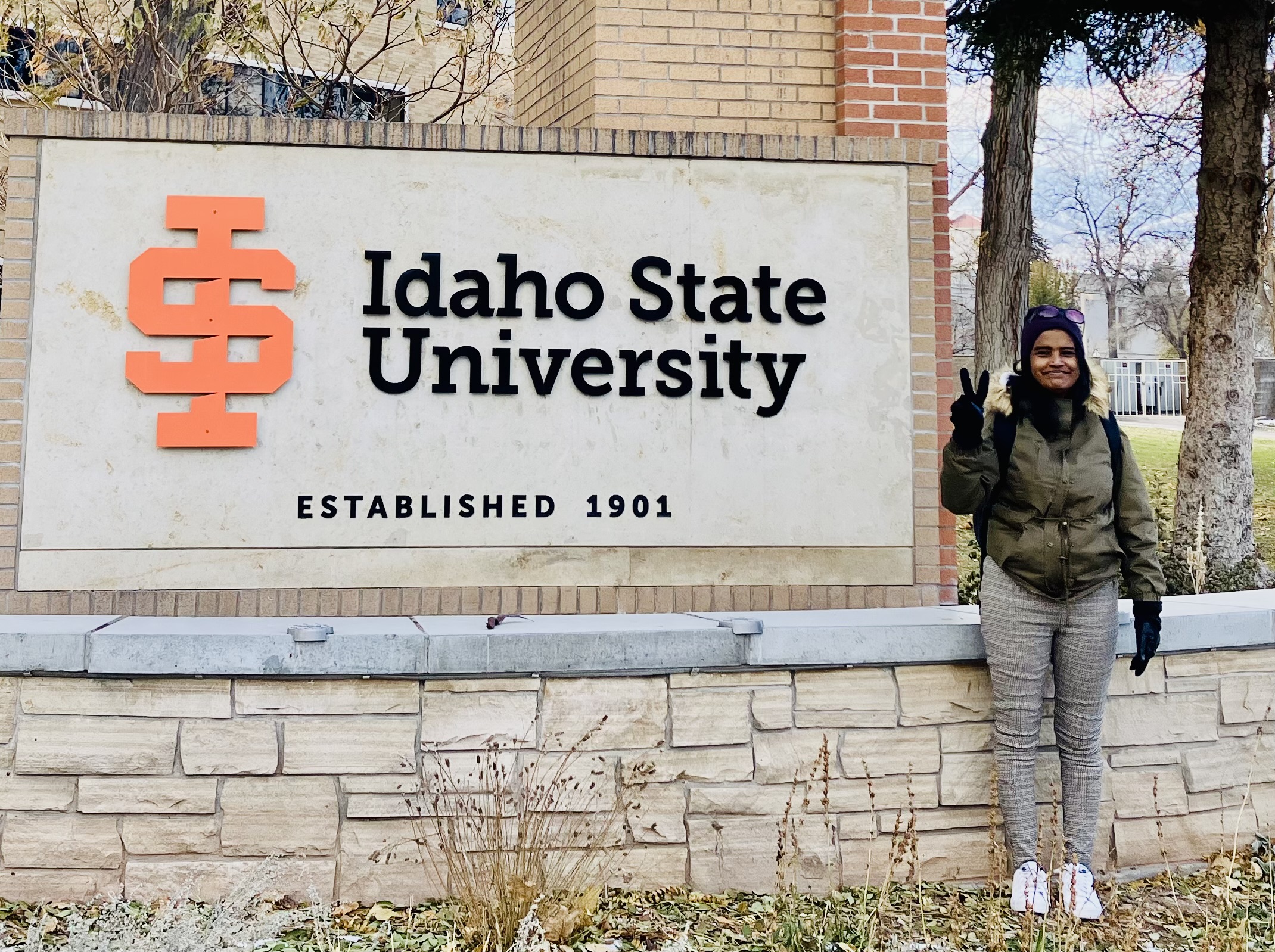 Suparna Sinha smiling in front of the Idaho State University sign