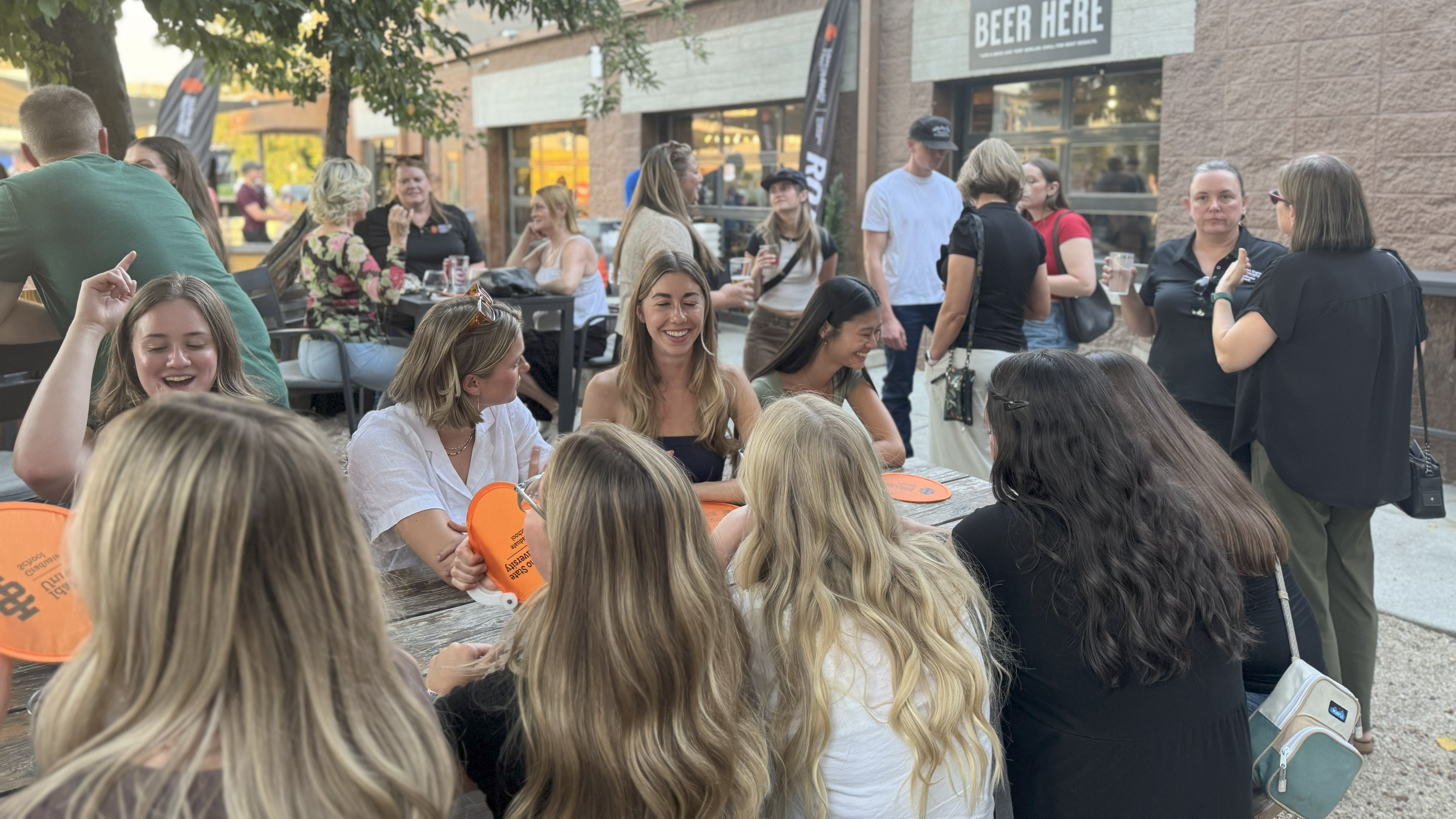 A group of graduate students chatting at a table on a patio