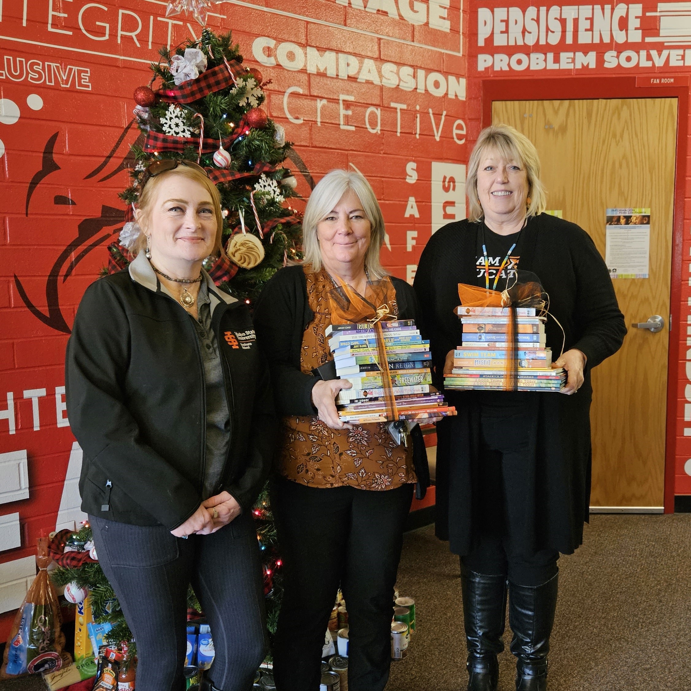 Grad School staff with Tyhee Elementary School staff, holding donated books