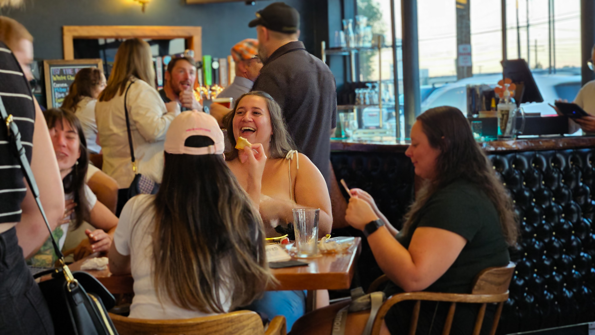Group of students at Late Nights sitting around a table and laughing