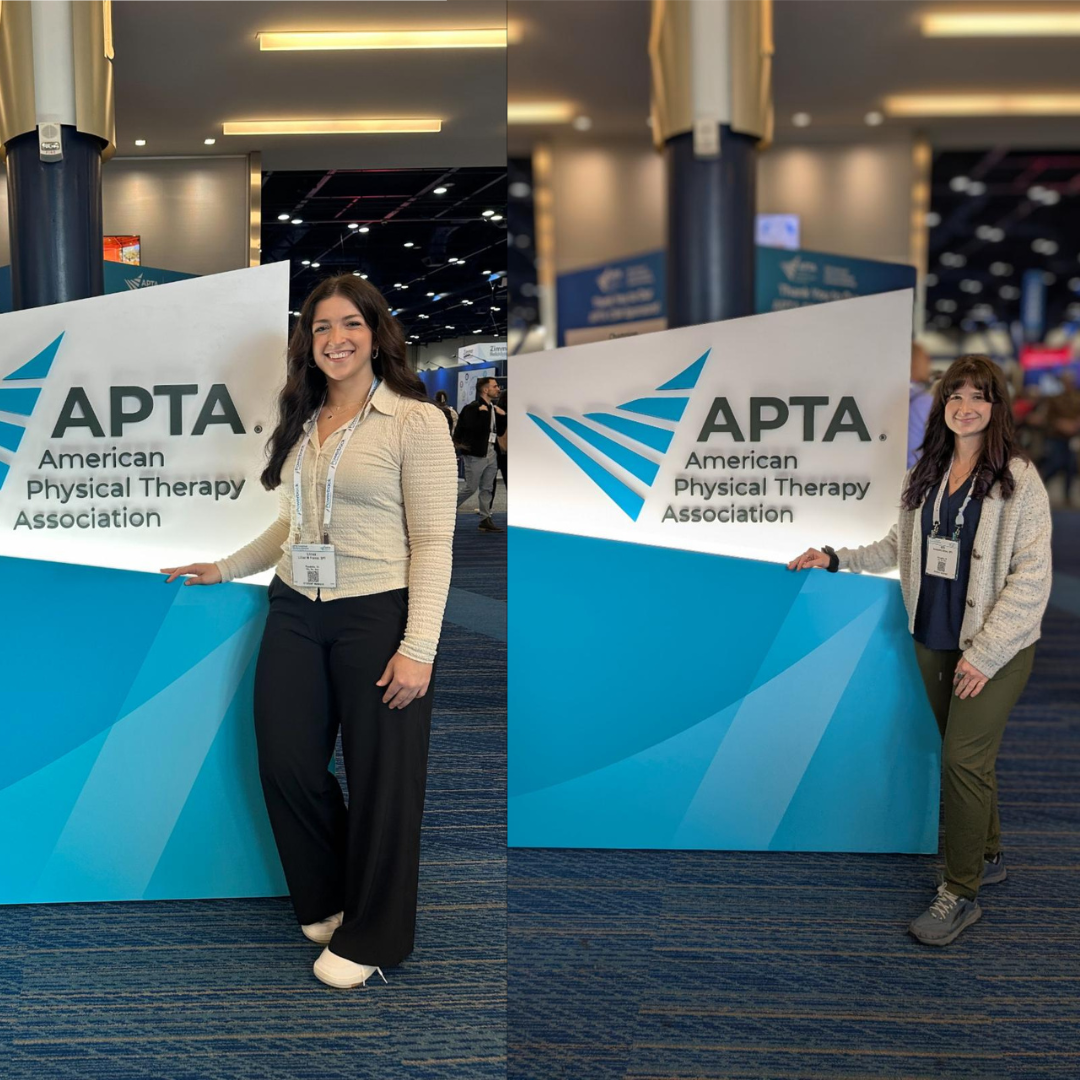 Alexandra Amico and Lillian France posing in front of a conference banner