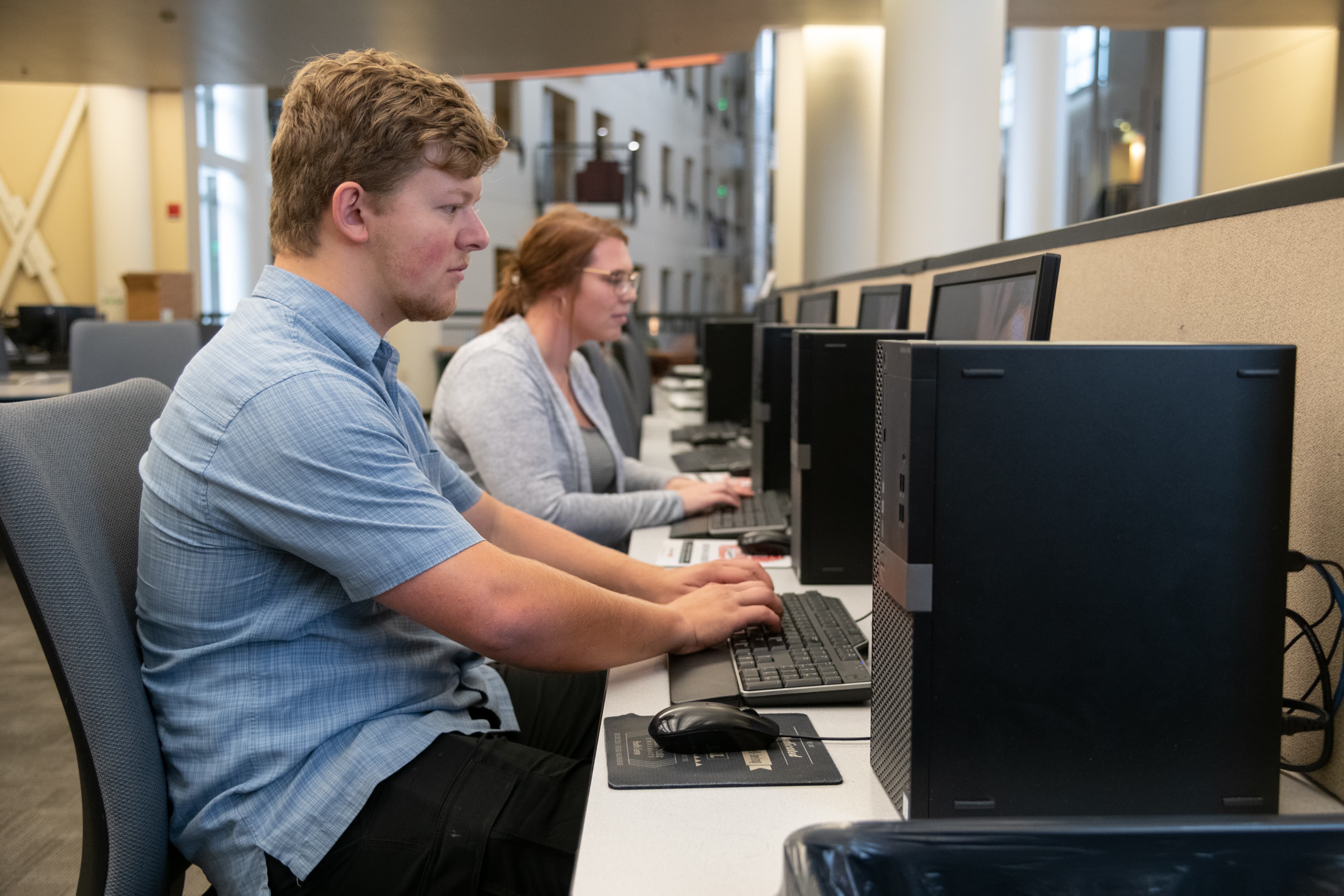 Viewed down the line, a students using computers in a computer lab.