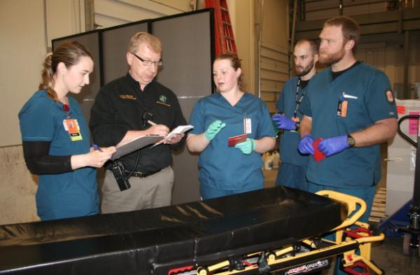 Team standing in line with clipboards to assess patients