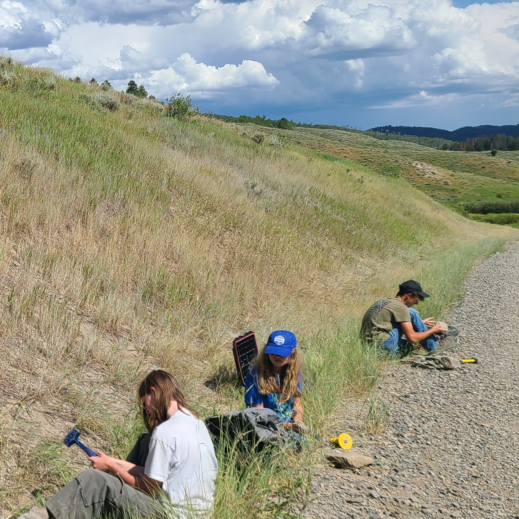 Three teens looking for fossils in rocky soil