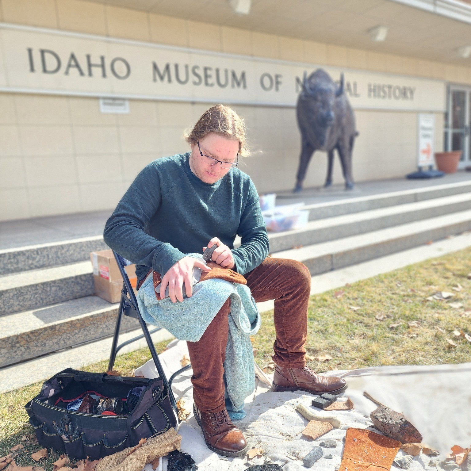A man breaking stone to create a stone tool