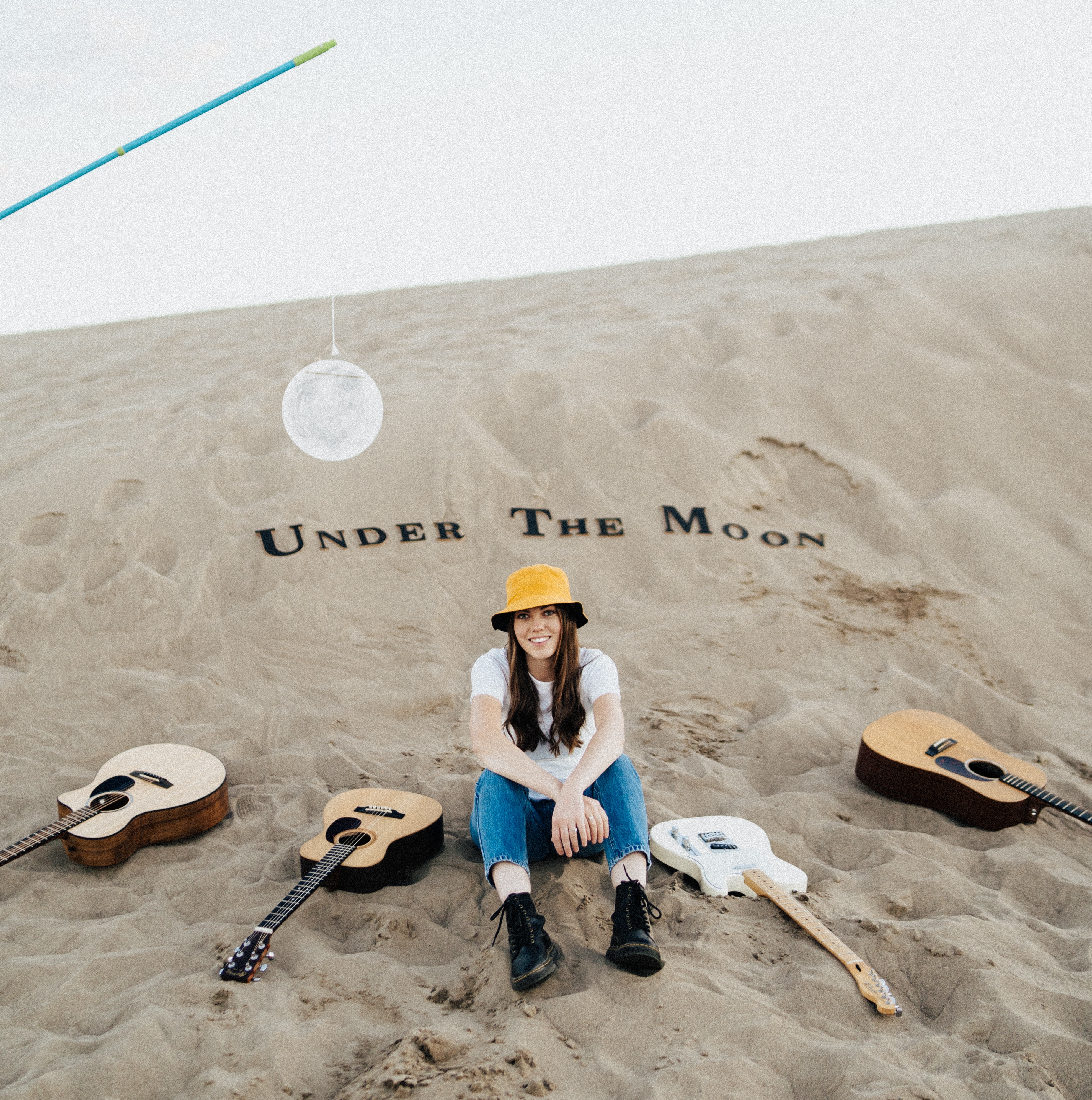 Claire sitting on the beach surrounded by instruments, album cover