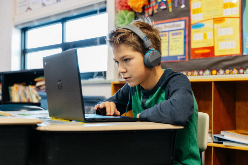 Student wearing headphones while working on a laptop