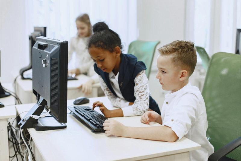 K-12 students working in front of a computer