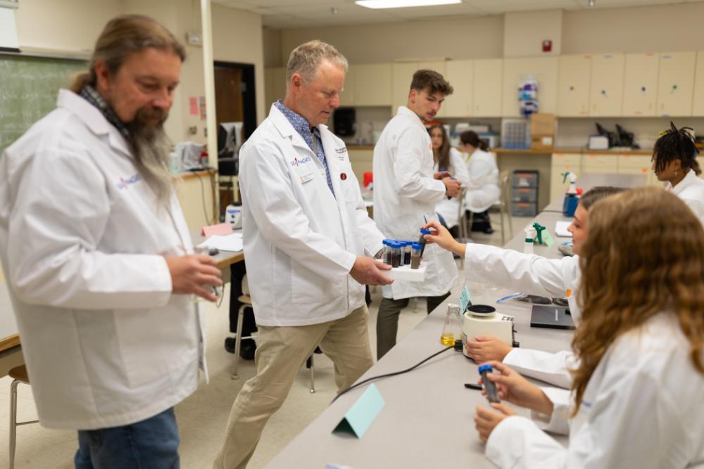 Michael Thomas, professor in the Department of Biological Sciences, helps students with their samples in the Bacteriophage Discovery and Genomics class on Tuesday, August 27, 2024.