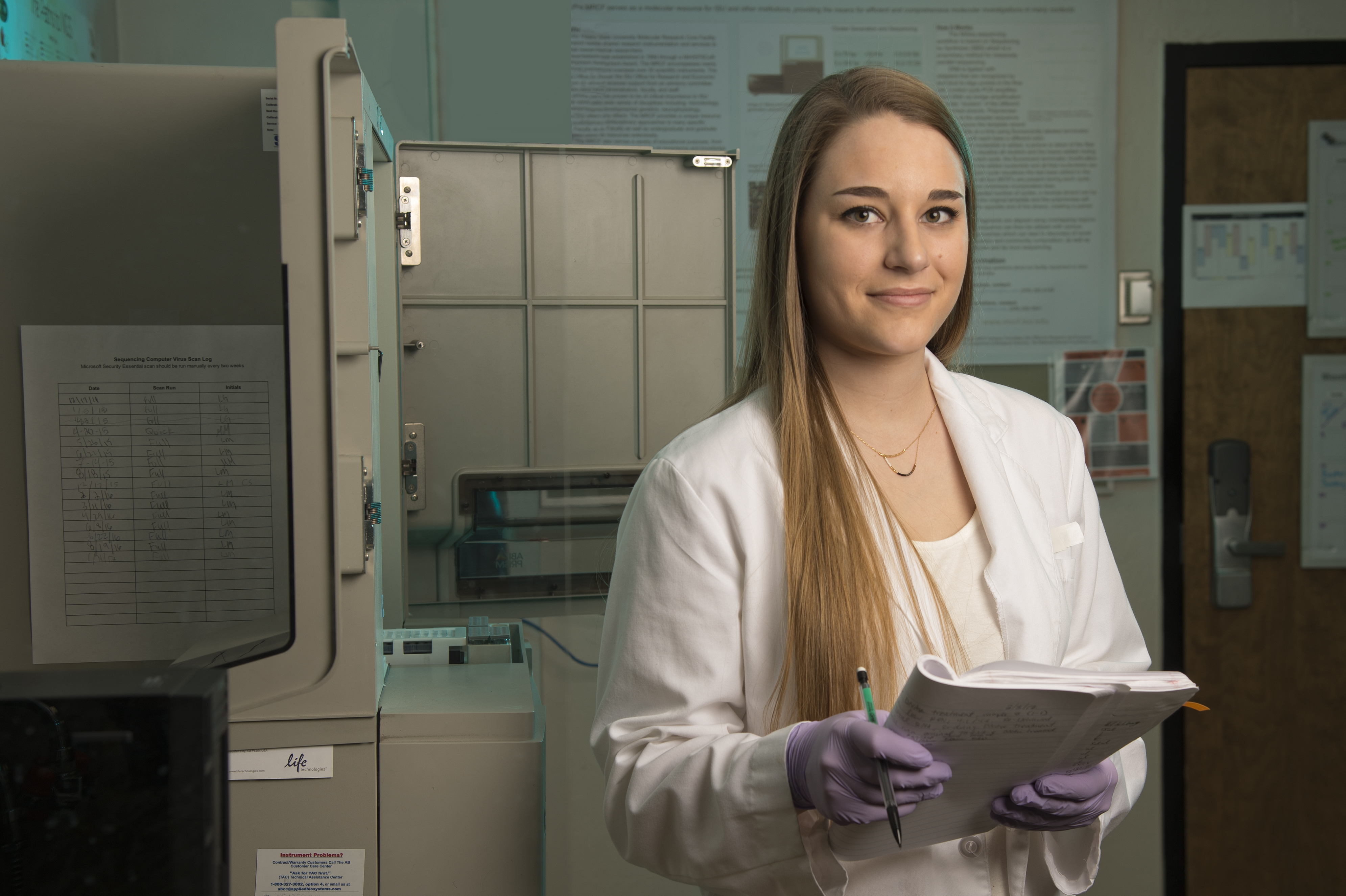 a student in a lab coat completing a laboratory inspection