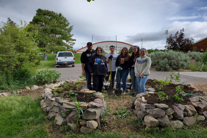 Geology Club and AmeriCorps members posing in a community garden