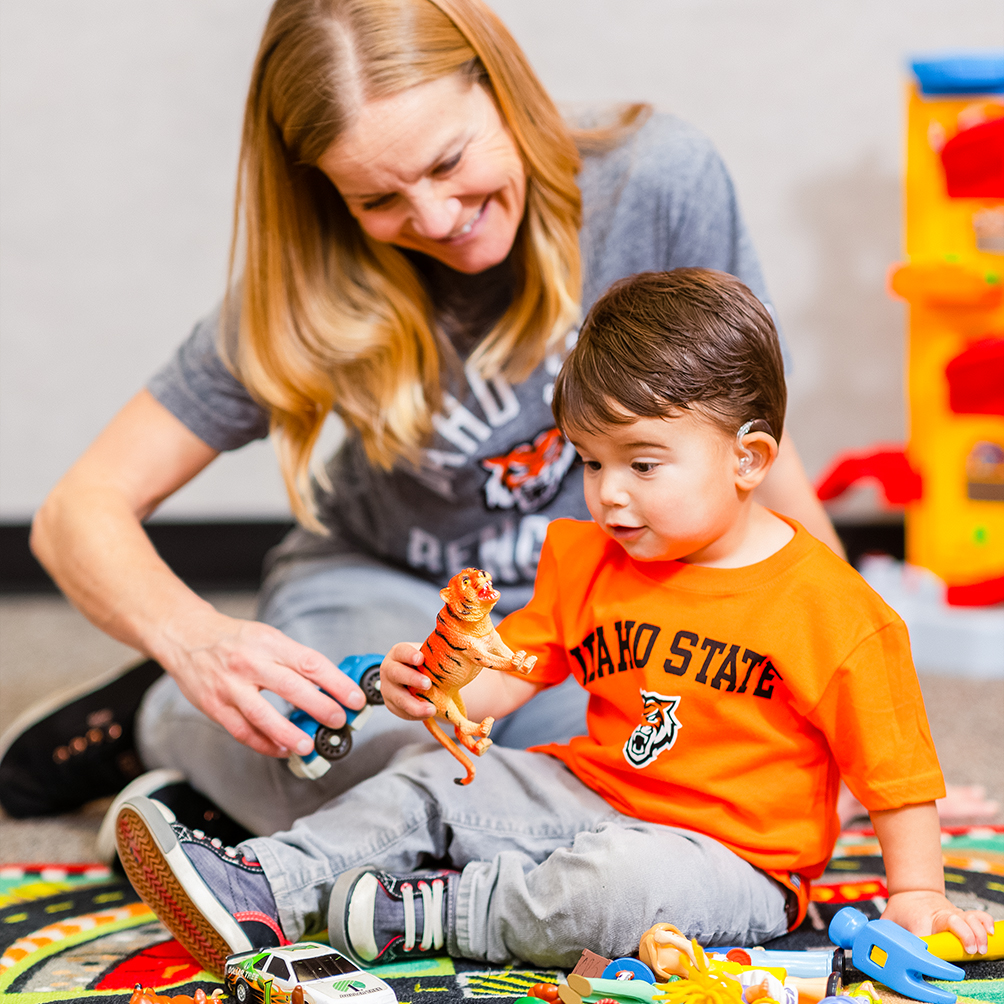 A staff member supervising a child in the Early Learning Center