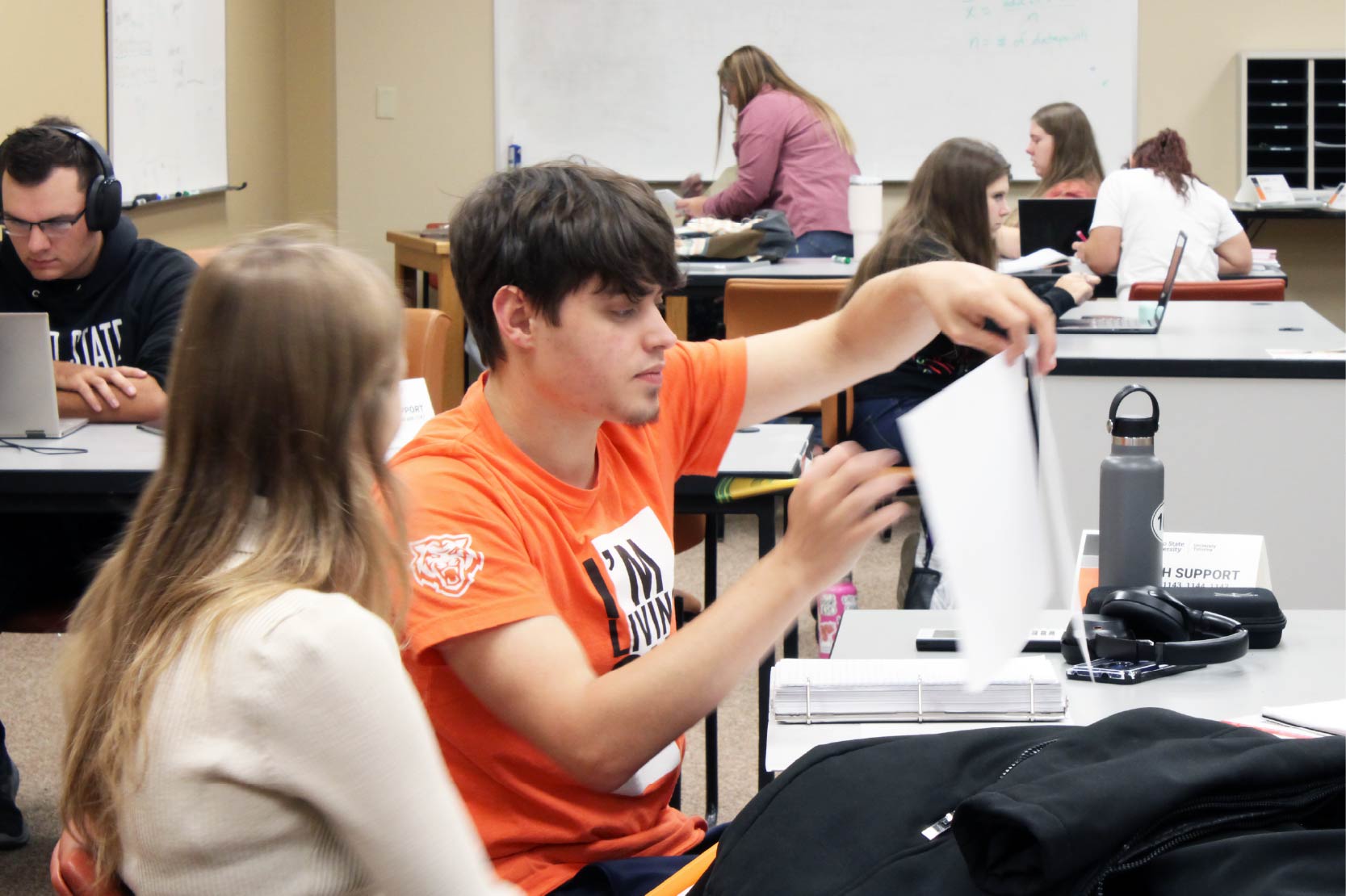 Room full of students and tutors studying together.