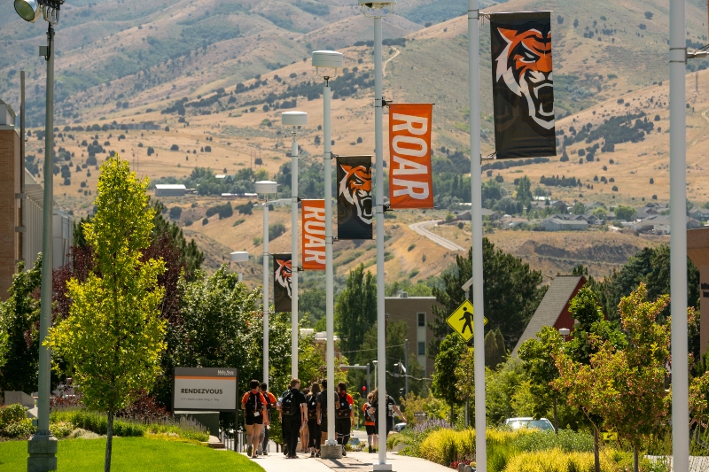 students walking on sidewalk under ISU roar and bengal flags