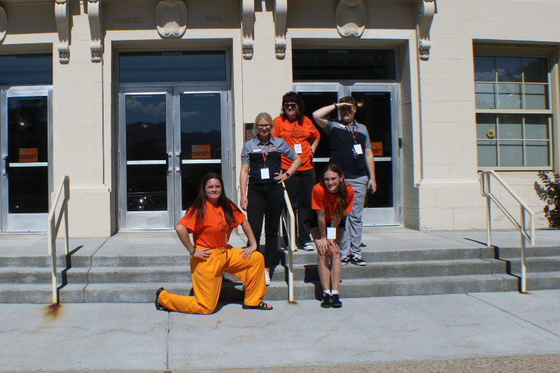 students standing in sun in front of building