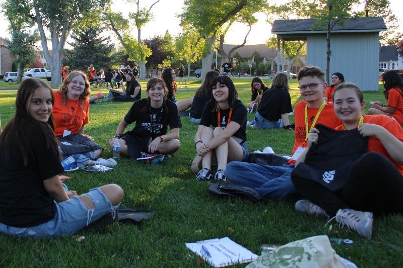 current students who are friends sitting on a lawn talking