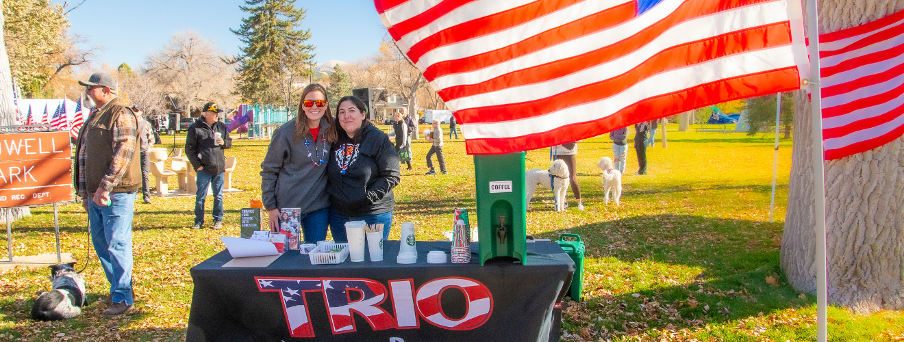 Two Veterans TRIO employees attending a veteran's day celebration looking for more veterans to help with school.