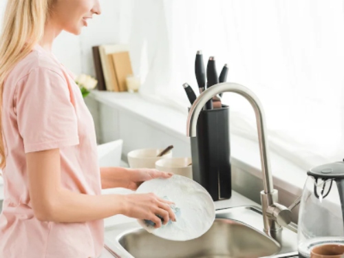 A woman washing dishes.