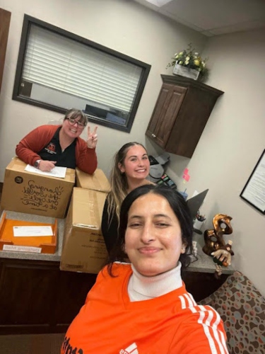 Three people boxing up products.