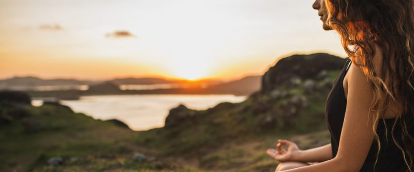 Spiritual wellness girl sitting looking at lake