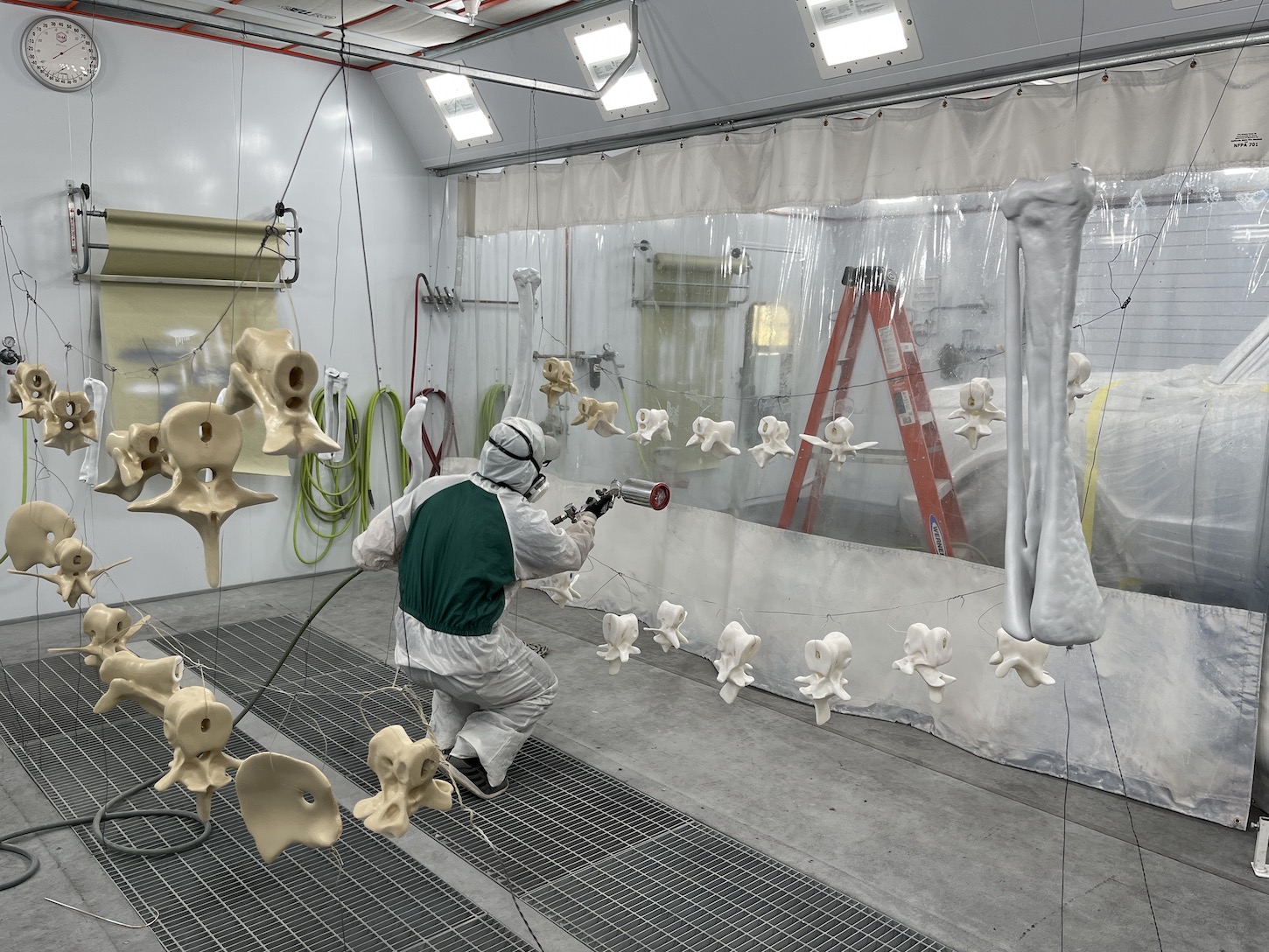 A man paints fabricated fossil parts